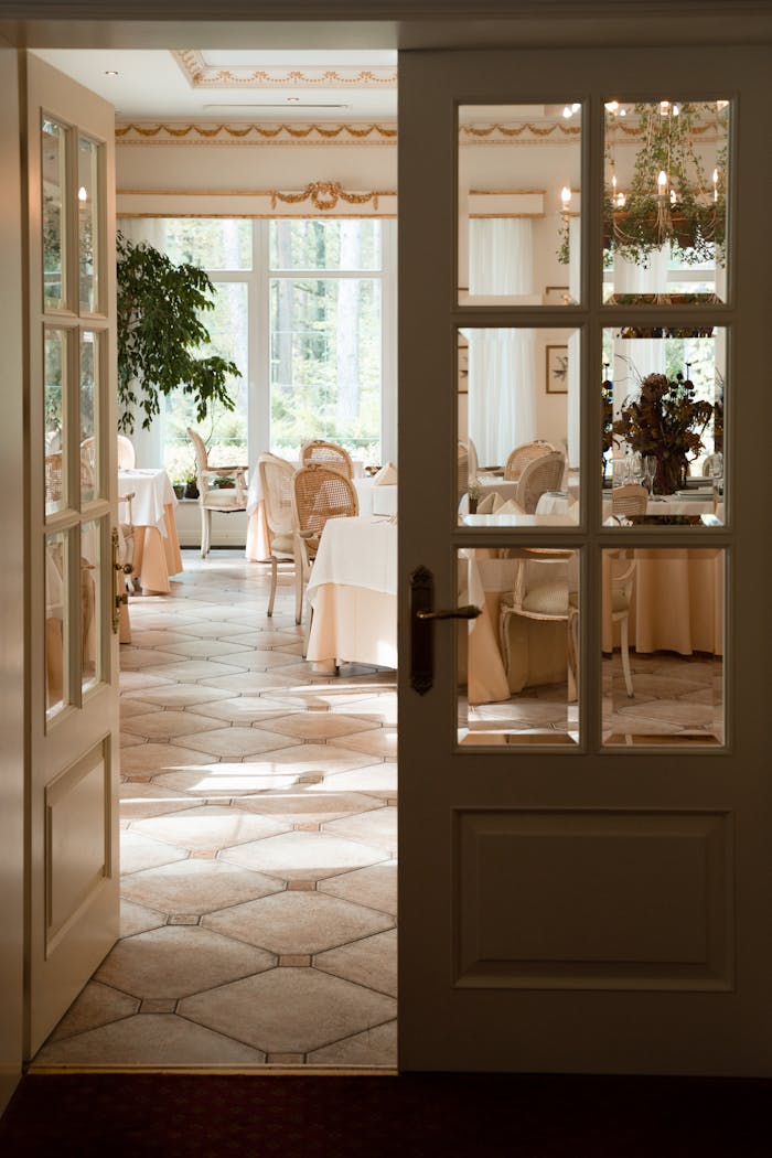 A bright and elegant dining area with open double doors revealing a cozy, sunlit interior.